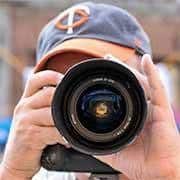 Photographer taking picture with large camera lens